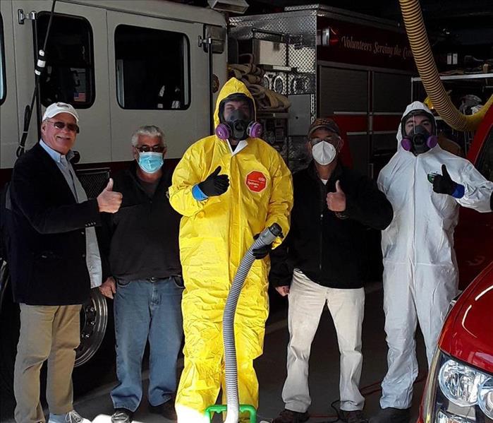 Employee in PPE with firefighters in Longport.