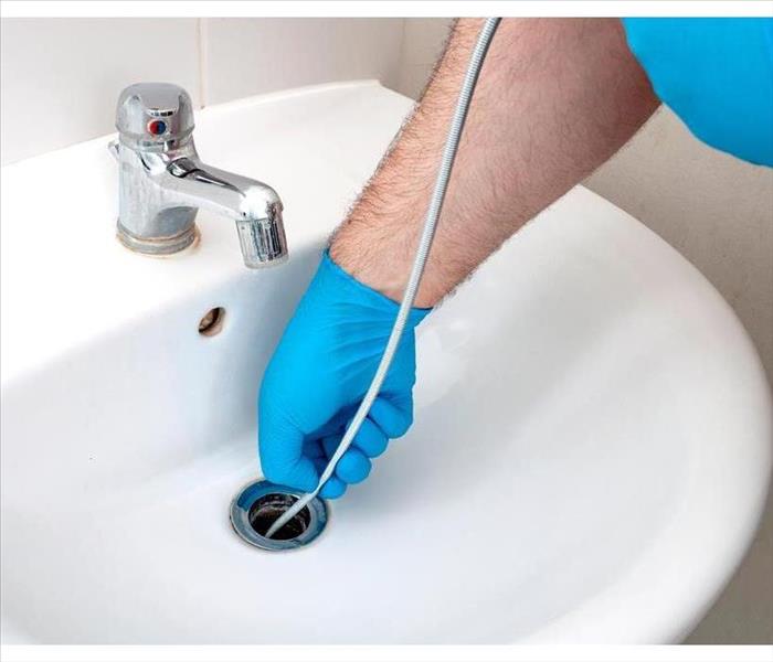 Inserting a drain auger in a sink